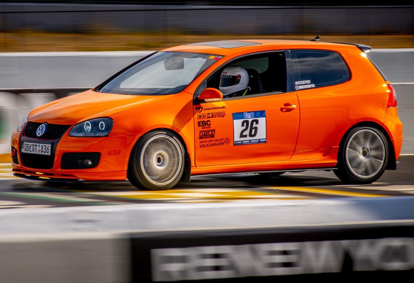 Kaytea driving her orange Volkswagen Fahrenheit GTI on a circuit